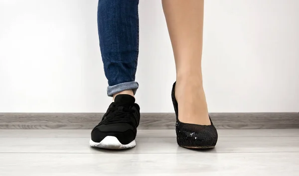 Two different types of shoes on the woman\'s foots