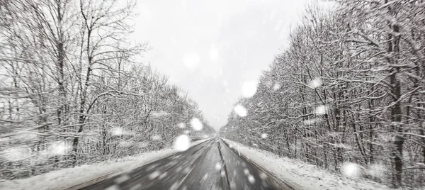 Асфальтовая дорога зимой и снежная погода снаружи — стоковое фото