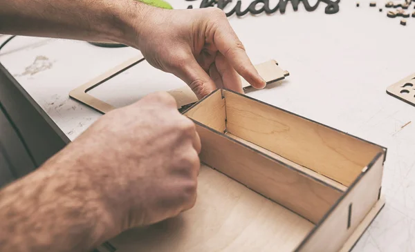 Чоловік робить дерев'яну коробку з фанери — стокове фото