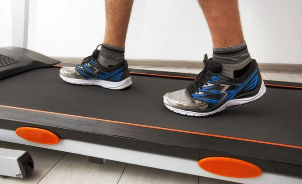 The man's legs in sneakers on the treadmill — Stock Photo, Image