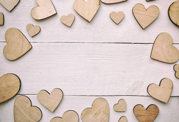 Un hermoso fondo con muchos corazones de madera en la t blanca — Foto de Stock