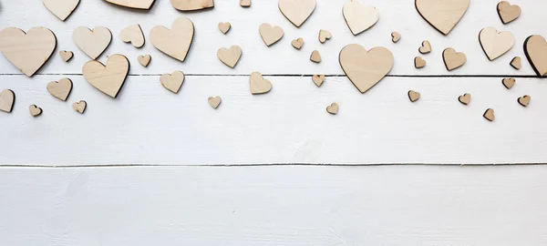 Un hermoso fondo con muchos corazones de madera en la t blanca — Foto de Stock