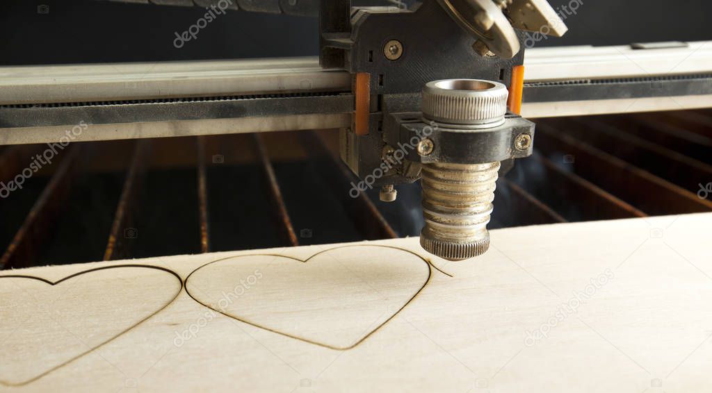 Laser cutting machine is cutting the wooden plank
