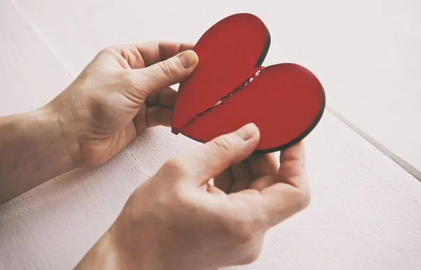 The broken red wooden heart in woman's hands — ストック写真