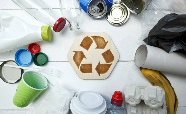 Um monte de lixo diferente sobre a mesa e o ícone de reciclagem b — Fotografia de Stock