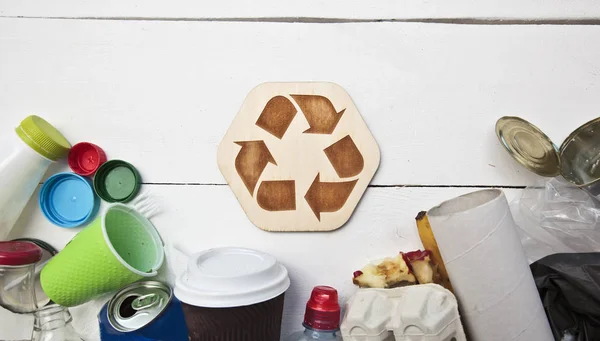 Um monte de lixo diferente sobre a mesa e o ícone de reciclagem b — Fotografia de Stock