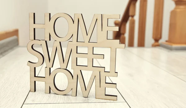 Phrase Home, sweet home made of wood on the background of new ho — Stock Photo, Image