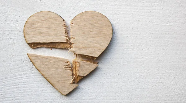 The broken wooden heart on the wooden table. Concept of the divo — Stock Photo, Image