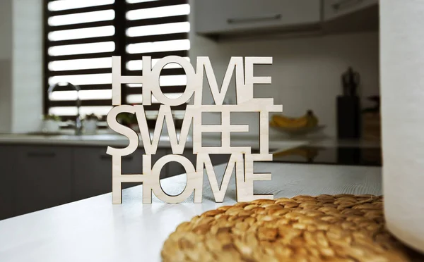 Phrase Home, sweet home made of wood on the background of kitche