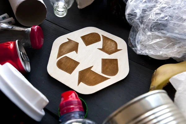 Un sacco di rifiuti diversi sul tavolo e l'icona di riciclaggio b — Foto Stock