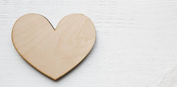 A beautiful background with af wooden heart on the white table — 스톡 사진