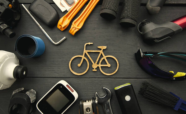A lot of different bicycle accessories lying on wooden table aro
