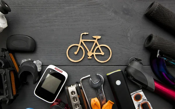 Una gran cantidad de diferentes accesorios de bicicleta acostado en la mesa de madera aro —  Fotos de Stock