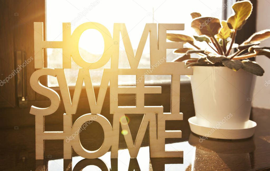 Phrase Home, sweet home made of wood on the background of new ho