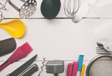 Ahşap masada bir sürü farklı mutfak gereçleri var.