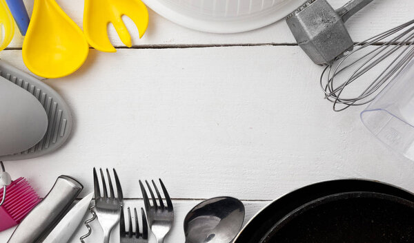 Lots of different kitchen utensils on the wooden table