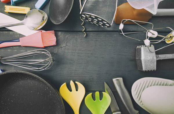 Lots of different kitchen utensils on the wooden table