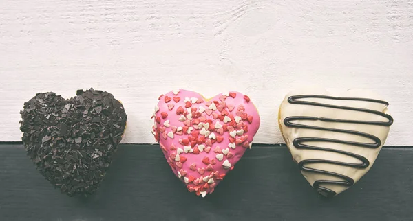 Three Delicious Donuts Shape Heart Wooden Table Stock Picture