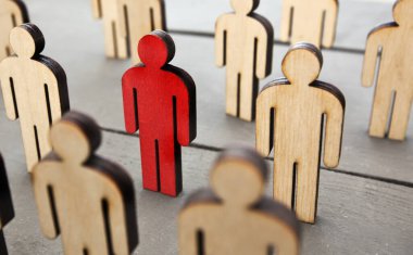 Masada altı ahşap insan ve bir kişi kırmızı renge boyanmış. Koronavirüs ya da başka bir virüs kavramı insanlara yayılıyor..