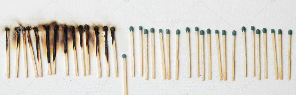 A lot of burnt matchsticks and one matchstick prevents following burning. Concept of stop spreading coronavirus and stay at home