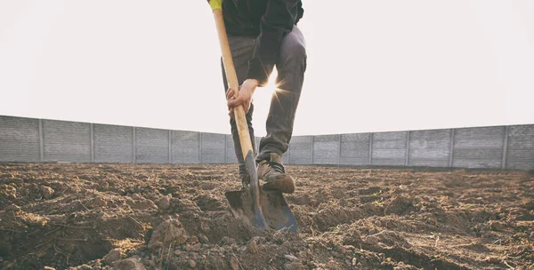 その男は自分の国の家に土を掘っている — ストック写真