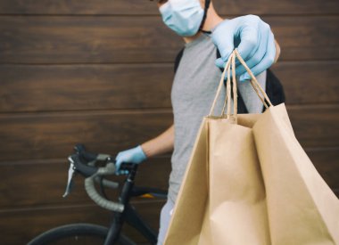 Bisikletli kurye, kese kağıdını kişiye teslim ediyor.