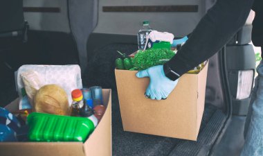 Kurye, karton eko kutusunu marketten çıkan ürünlerle birlikte karavandan çıkarır.