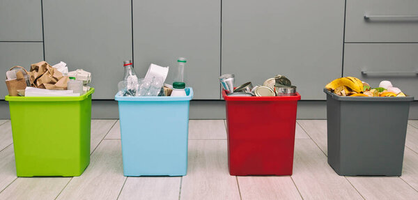 Четыре разных контейнера для сортировки мусора. Для пластмасс, бумаги, металла и органических отходов
