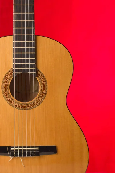 Akoestische gitaar op rode achtergrond — Stockfoto