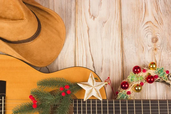 Cowvoy Kerstmis achtergrond met gitaar en cowboy western hoed — Stockfoto