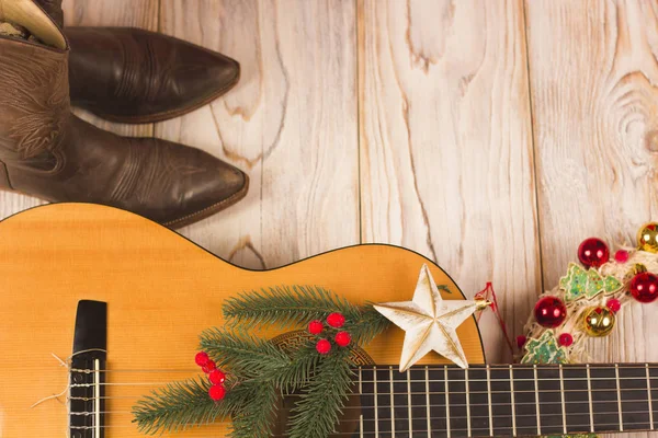 Fondo de navidad vaquero con la guitarra y botas de vaquero — Foto de Stock