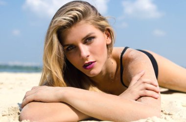 Lüks sarışın siyah iç çamaşırı kumlu bir plaj üzerinde yalan