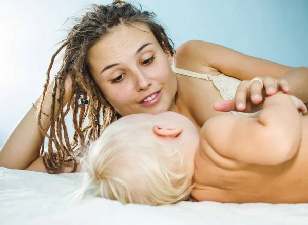 Moeder en dochter liggen op het bed. Ze net wakker en lachen — Stockfoto