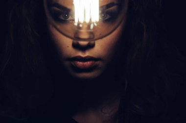 Kadın ampul ile gizemli fotoğrafı. Portre karanlıkta. Tehlikeli kız.