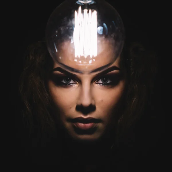 Mystiska foto av kvinna med glödlampa. Porträtt i mörkret. Farlig tjej. — Stockfoto