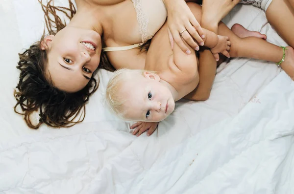 엄마와 아기 침대에 한 여자와 그녀의 todler 침실에 누워 재생. — 스톡 사진