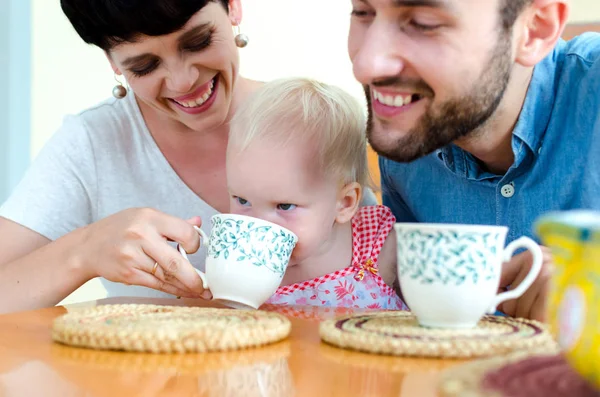 Jonge familie thuis in het weekend. Familie thee drinken. — Stockfoto