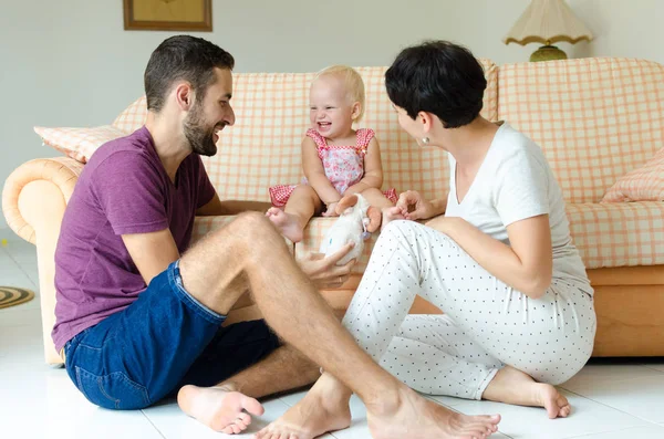 Man en vrouw spelen met een kind. Jonge familie thuis in het weekend. — Stockfoto