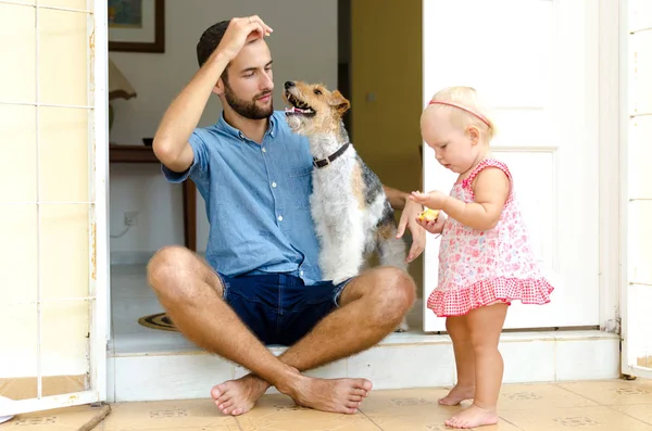 Papa et fille et leur chien. Un homme et une fille près de chez elle sous le porche. À côté d'eux leur animal de compagnie . — Photo