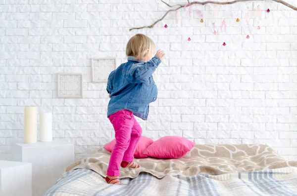 Lyckligt barn tjej hoppar på sängen — Stockfoto
