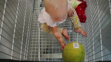 Bir süpermarkette bir alışveriş arabası olan bir çocuk.