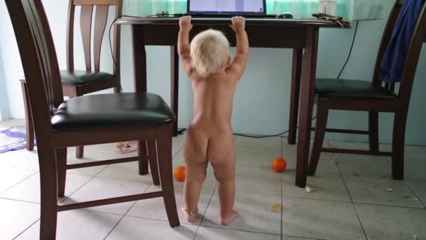 Ребенок держится за стол и танцует . — стоковое видео