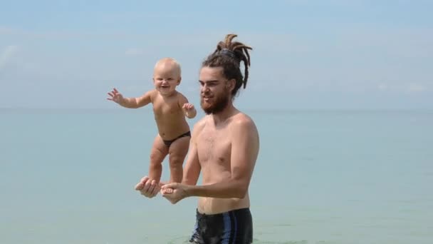 お父さんと子供が海で泳いでいます。. — ストック動画