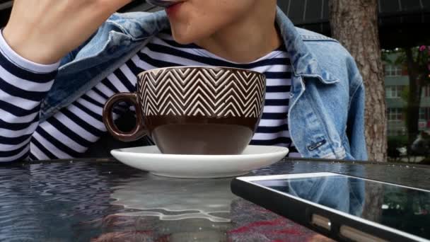 Una ragazza sta bevendo cappuccino da una grande tazza . — Video Stock