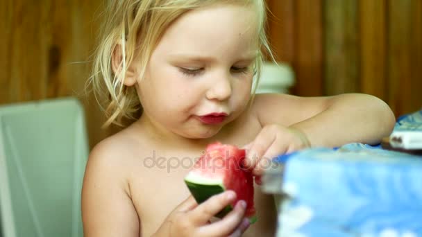 A criança come uma melancia . — Vídeo de Stock