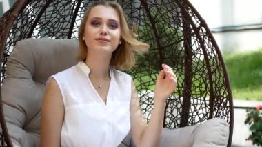 Beyaz elbiseli bir kız bir yeşil elma yiyor.