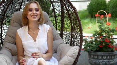 Beyaz elbiseli bir kız bir yeşil elma yiyor.