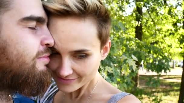 Una giovane coppia che fa selfie. Un tizio con la barba e una ragazza con i capelli corti si è tagliato e si è divertito davanti alla telecamera . — Video Stock