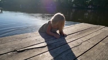 Çocuk köprüden havuzda su çalışır.