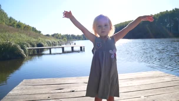 La fille sur la jetée se réjouit au soleil . — Video